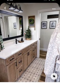 a large bathroom with wooden cabinets and white counter tops, along with pictures on the wall