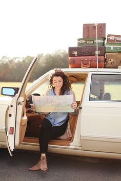 a woman sitting in the back of a car holding a map