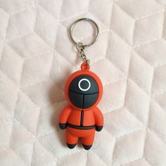 an orange keychain with a black and white figure on it's side