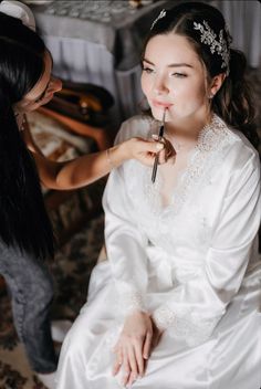 the bride is getting her makeup done