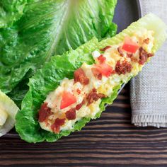 lettuce wraps with bacon and cheese on them sitting on a plate next to a napkin