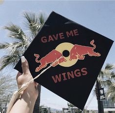 someone is holding up a graduation cap that says gave me wings with a bull on it