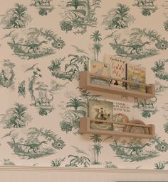 two bookshelves are on the wall in front of a wallpapered wall