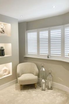 a living room filled with furniture and white shutters on the window sill's