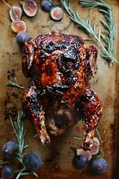 a roasted chicken with figs and rosemary sprigs