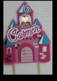 a pink cake topper with a castle on it and the word garmen