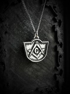 This Square and compasses necklace is an handmade pewter sculpture of my own creation, it is inspired by a gravestone at Elmwood Cemetery (Sherbrooke, Canada)The square and compass is commonly associated to the freemasonry, the meaning is debated and may change between individuals and cultures. The letter G is sometimes associated with the G from God, while Eliphas Levi associate it with Great Architect. This necklace is 24mm x 27mm This square and compass Pendant is sold with a 18'' or 24'' sta Stamped Silver Brass Jewelry, Symbolic Pewter Jewelry As Gift, Symbolic Pewter Jewelry For Gifts, Engraved Pewter Round Pendant Jewelry, Engraved Pewter Pendant Jewelry, Symbolic Antique Silver Medallion Jewelry, Symbolic Antique Silver Pewter Jewelry, Symbolic Antique Silver Nickel-free Jewelry, Symbolic Pewter Jewelry With Adjustable Fit