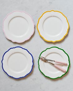 four plates with different colored trimmings and one has a pair of scissors on it