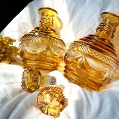 three glass vases sitting next to each other on a white cloth