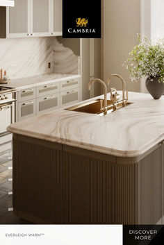 a kitchen with marble counter tops and white cabinets, along with a gold faucet