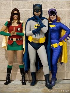 three people dressed up as batman and robin wayne standing in front of a brick wall