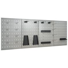 a large metal wall mounted to the side of a building with multiple holes in it