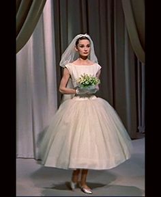 a woman in a wedding dress holding a bouquet