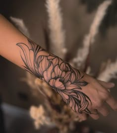 a woman's arm with a flower tattoo on it