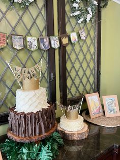 there are two cakes on the table with pictures hanging from it's sides and decorations around them