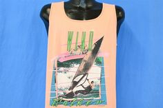 "Chest 20.5 in. Length 24 in. Tag Says: Sun, 50% polyester 50% cotton, large This shirt features a vibrant graphic of a windsurfer and the words, \"Wind Walker.\" Windsurfing is a popular offshoot of traditional surfing that's very accessible to beginners, as it's great to do on flat waters. The record for the longest journey via windsurf board was completed by Jono Dunnett who surfed from Norway to the Black Sea, over 8,000 miles, in a little under 2 years. Comments: Fits like a modern unisex a Ocean Sports, The Longest Journey, Surfing Waves, Windsurfing, Black Sea, Top T Shirt, Graphic Tank Top, Norway, Surfing