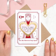 a woman holding up a card with a queen of my heart on it and gold foil