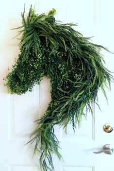 a horse head made out of green plants on a door handle and some knobs