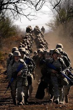 a group of soldiers walking down a dirt road