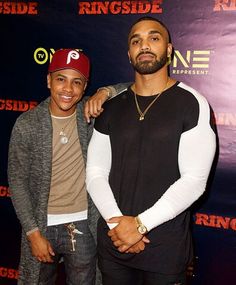 two men standing next to each other in front of a red and blue sign with the words ring side on it