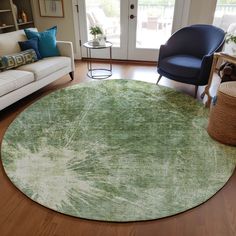 a living room filled with furniture and a green rug on top of a hard wood floor