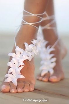 a woman's feet with white flowers on them