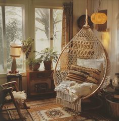 a living room with a hammock hanging from the ceiling and pillows on the floor