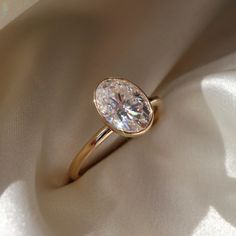 a close up of a diamond ring on a white cloth