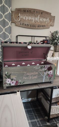 a wooden box with flowers painted on it sitting on top of a table next to other boxes