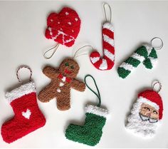 crocheted christmas stocking ornaments are arranged on a white surface with red and green stockings