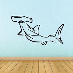 a drawing of a shark on a wall in a room with wood flooring and blue walls