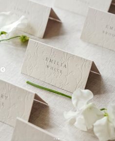 some white flowers and place cards on a table