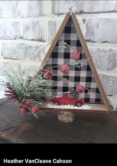 a small christmas tree decorated with red and black plaid fabric, pine cones, snowflakes and car ornaments