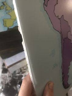 a person holding up a piece of paper with a map on it