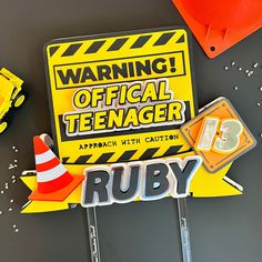 a yellow warning sign sitting on top of a table next to traffic cones and construction equipment