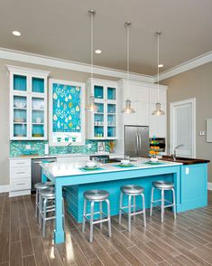 a kitchen with blue counter tops and stools next to an island in the middle