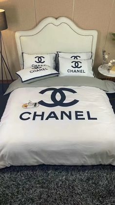 a bed with chanel pillows on it