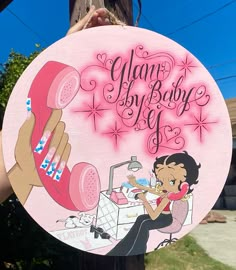 a pink sign with an image of a woman talking on the phone and writing glam baby life