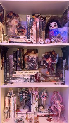 a book shelf filled with lots of books and anime figurines on top of it