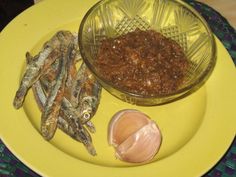 an assortment of food on a yellow plate next to a garlic and pepper shaker