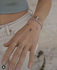 a woman's hand with tattoos on her left wrist and the words inkster lieson written across it