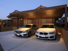 two white cars parked in front of a house