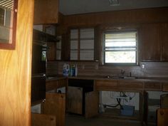 an empty kitchen with wooden cabinets and appliances