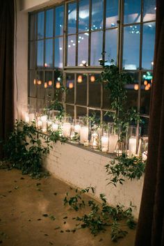 many candles are lit in front of a window