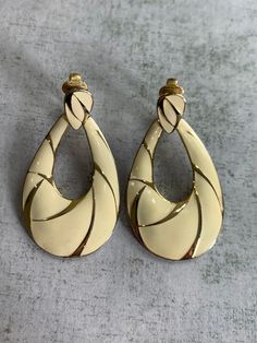 Nice pair of vintage clip on earrings. Gold setting with cream enamel in a teardrop doorknocker shape. Signed TAT. Good condition - some wear to the gold on back. Doorknockers Earrings, Vintage Clip On Earrings, Vintage Clip, Wedding Jewelry Earrings, Gold Set, Lace Up Flat, Wedding Earrings, Earrings Gold, Clip On