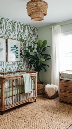 a baby's room decorated in green and white with palm leaves on the wall