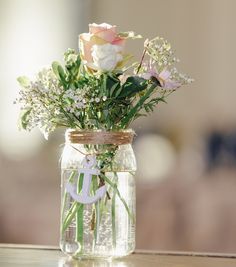 a mason jar filled with flowers on top of a table