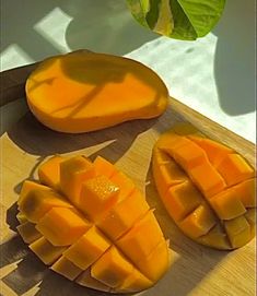 slices of mango on a cutting board with leaves in the background