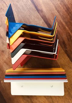 a stack of different colored papers on top of a wooden table