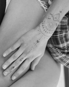 a woman's arm with tattoos on it and her hand holding the other arm